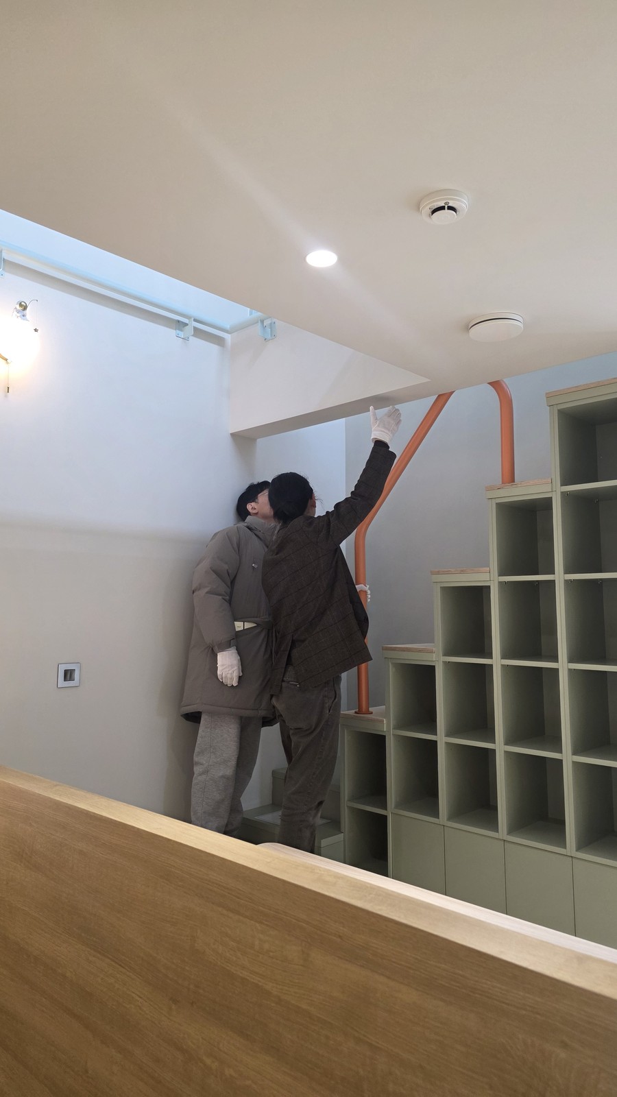 오픈하우스에 방문한 손님들이 그물침대 위 고측창을 가리키고 있다.